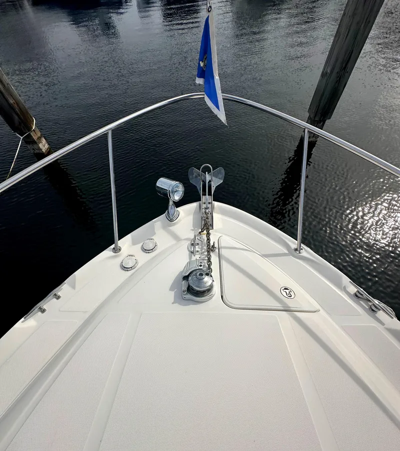 Slide: The Image of 2003 Sea Ray 340 Sundancer bow with anchor and flag on calm water. - 14