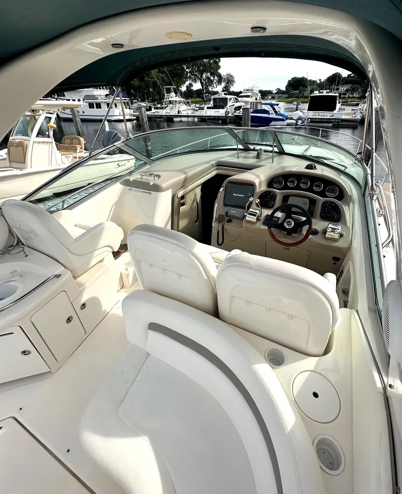 Slide: The Image of 2003 Sea Ray 340 Sundancer cockpit with helm, seating, and marina view. - 26