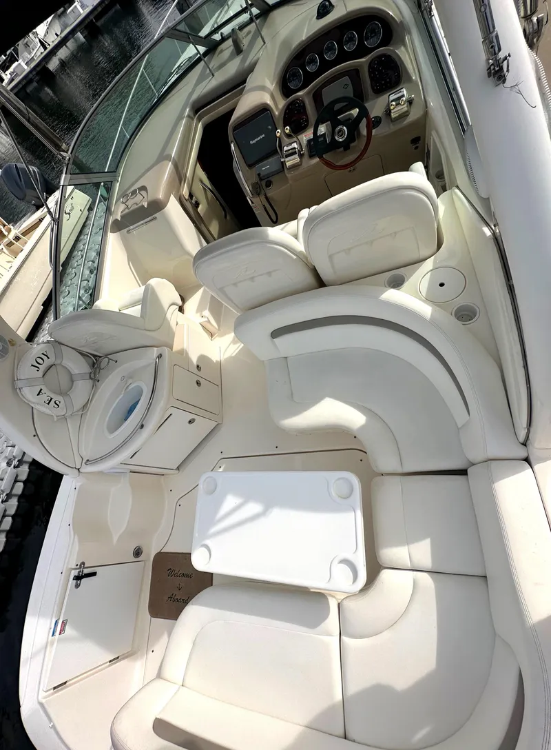 Slide: The Image of 2003 Sea Ray 340 Sundancer boat interior with white seating and control panel. - 27