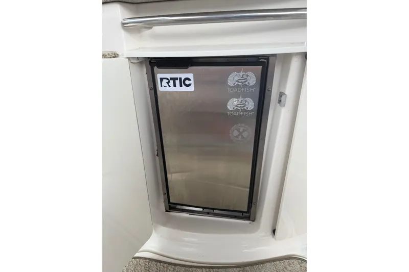 Slide: The Image of Stainless steel fridge door on 2005 Chaparral Signature 350 boat, featuring RTIC and Toadfish stickers. - 22