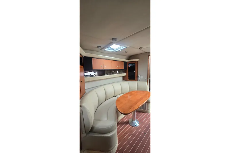 Slide: The Image of Interior of 2005 Chaparral Signature 350 yacht with curved seating and wooden table. - 25