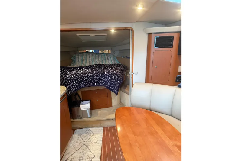 Slide: The Image of 2005 Chaparral Signature 350 cabin interior with bed, seating, and wooden table. - 44