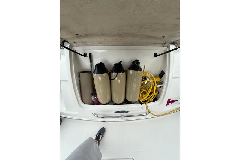 Slide: The Image of Storage compartment of 2005 Chaparral Signature 350 boat with fenders and yellow hose. - 45