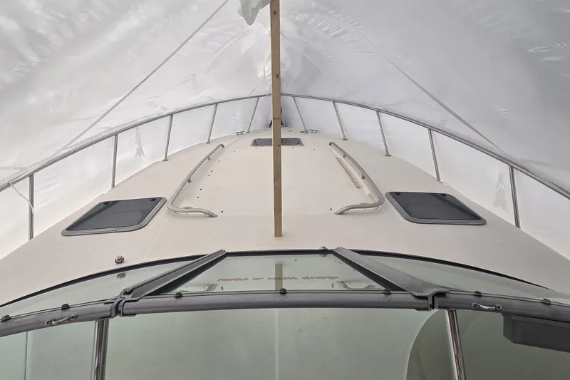 Slide: The Image of 2005 Chaparral Signature 350 boat under protective cover, showcasing deck and hatches. - 5