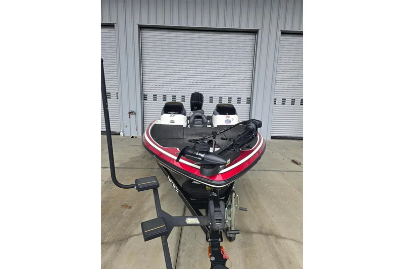 Slide: The Image of 2014 Nitro Z-7 boat with red accents parked in front of garage doors. - 2