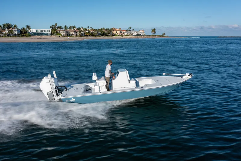 Slide: The Image of 2026 Billfish 24 boat cruising on ocean near coastal homes. - 4