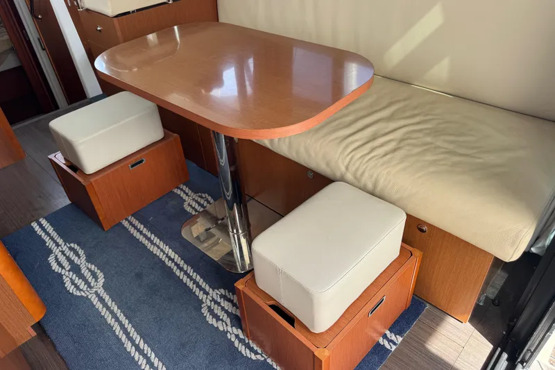 Slide: The Image of Interior of 2016 Beneteau Swift Trawler 30 with wooden table and cushioned seating. - 15