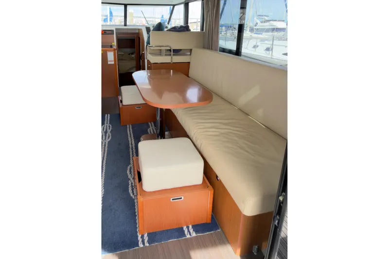 Slide: The Image of Interior of 2016 Beneteau Swift Trawler 30 with beige seating and wooden table. - 16