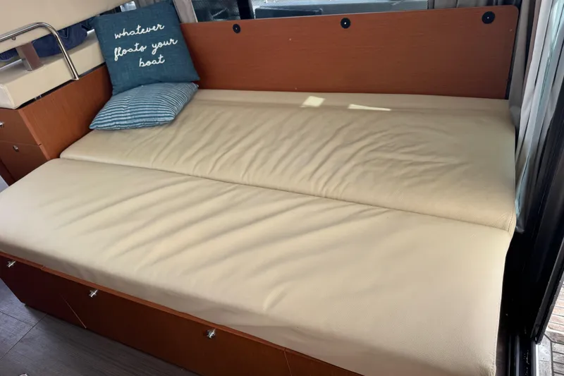 Slide: The Image of Interior of 2016 Beneteau Swift Trawler 30 with beige seating and decorative pillows. - 18