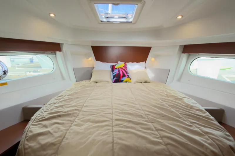 Slide: The Image of Interior cabin of 2016 Beneteau Swift Trawler 30 with cozy bed and porthole windows. - 21