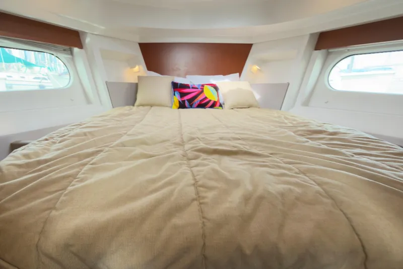 Slide: The Image of Cozy cabin interior of 2016 Beneteau Swift Trawler 30 with plush bedding and colorful pillow. - 23