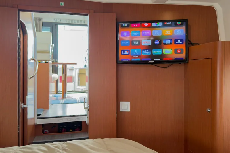 Slide: The Image of Interior of 2016 Beneteau Swift Trawler 30 with wall-mounted TV and wooden finish. - 25