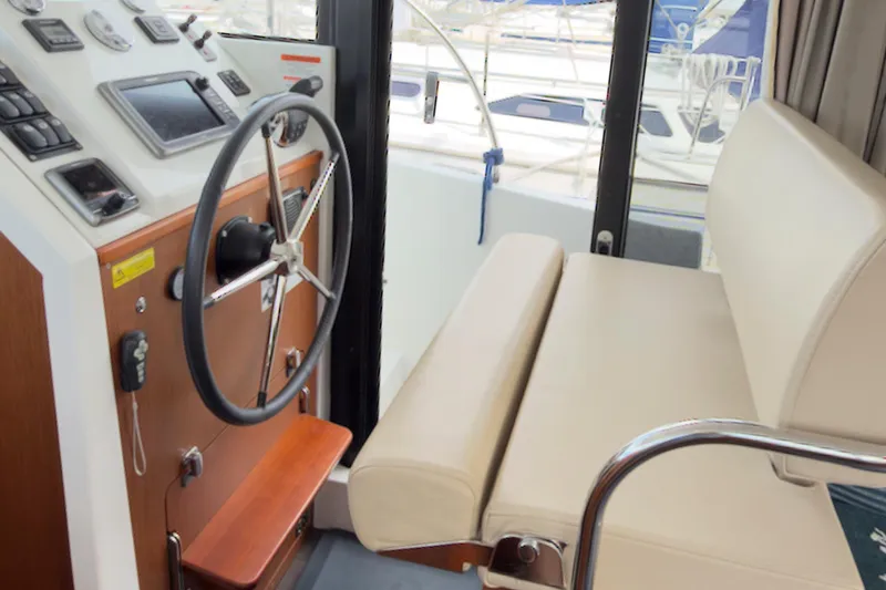 Slide: The Image of 2016 Beneteau Swift Trawler 30 helm station with steering wheel and navigation controls. - 33