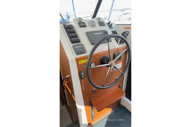 Slide: The Image of Helm station of 2016 Beneteau Swift Trawler 30 with steering wheel and navigation controls. - 34