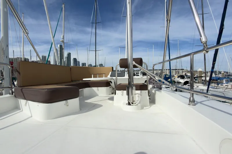 Slide: The Image of 2016 Beneteau Swift Trawler 30 deck with seating, marina background, clear sky. - 44