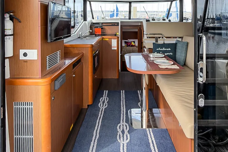 Slide: The Image of Interior of 2016 Beneteau Swift Trawler 30, featuring kitchen and dining area. - 7