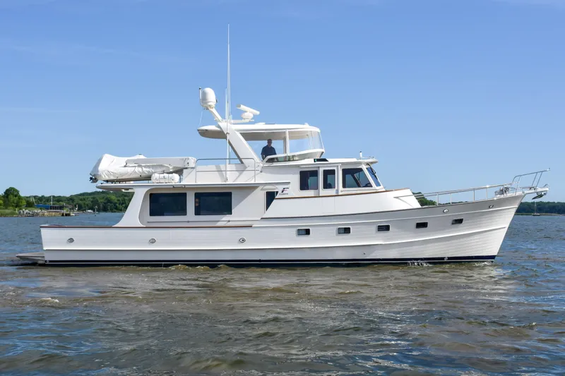 The Image of 2013 Fleming 55 yacht cruising on a calm river under a clear blue sky. - 0