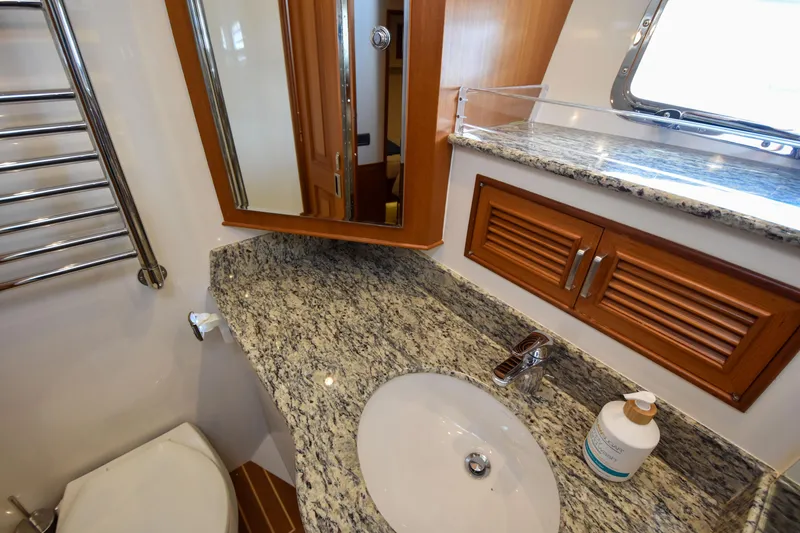 Slide: The Image of Luxurious bathroom in 2013 Fleming 55 yacht with granite countertop and wooden cabinetry. - 13