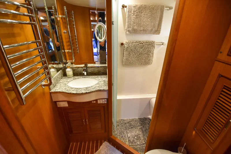 Slide: The Image of Luxurious bathroom in 2013 Fleming 55 yacht with granite countertop and wooden cabinetry. - 16