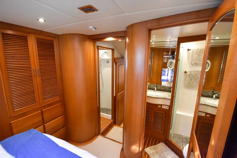 Slide: The Image of Luxurious 2013 Fleming 55 yacht interior with wood finish, featuring a bathroom and storage. - 17
