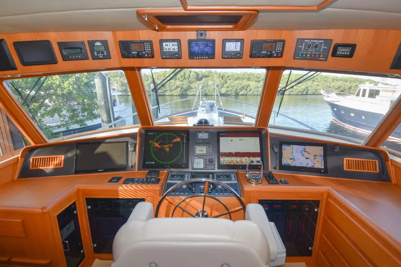 Slide: The Image of Cockpit of 2013 Fleming 55 yacht with navigation equipment and scenic marina view. - 18
