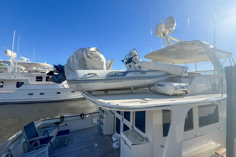 Slide: The Image of 2013 Fleming 55 yacht with a tender on deck, docked under clear blue skies. - 27