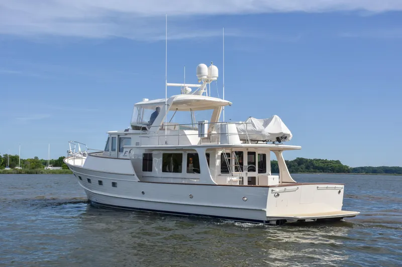 Slide: The Image of 2013 Fleming 55 yacht cruising on a calm, scenic waterway under a clear blue sky. - 30