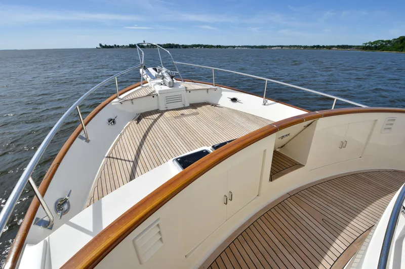 Slide: The Image of 2013 Fleming 55 yacht deck with wooden finish, cruising on open water. - 32