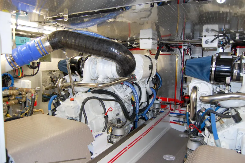 Slide: The Image of Engine room of a 2013 Fleming 55 yacht, showcasing dual engines and intricate piping. - 35