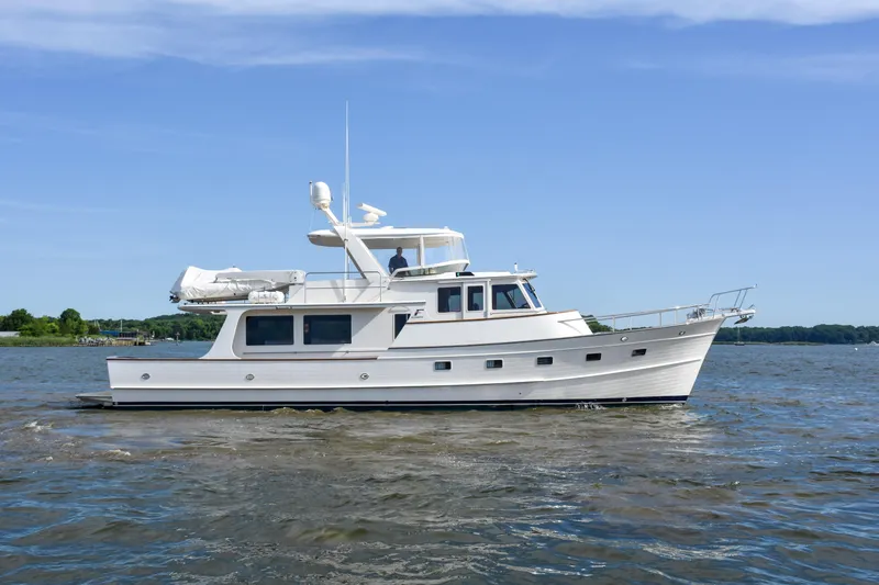 Slide: The Image of 2013 Fleming 55 yacht cruising on a calm river under a clear blue sky. - 37