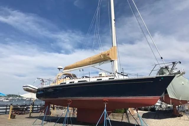 The Image of 1989 Freedom 38 Sloop sailboat on stands, clear sky background. - 0
