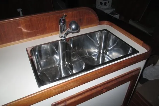 Slide: The Image of Stainless steel double sink on 1989 Freedom 38 Sloop yacht with wooden trim. - 12