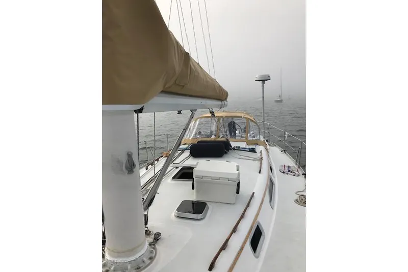 Slide: The Image of 1989 Freedom 38 Sloop sailboat on misty water, featuring deck and mast. - 19