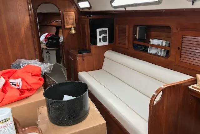 Slide: The Image of Interior of 1989 Freedom 38 Sloop sailboat with white seating and wooden accents. - 2