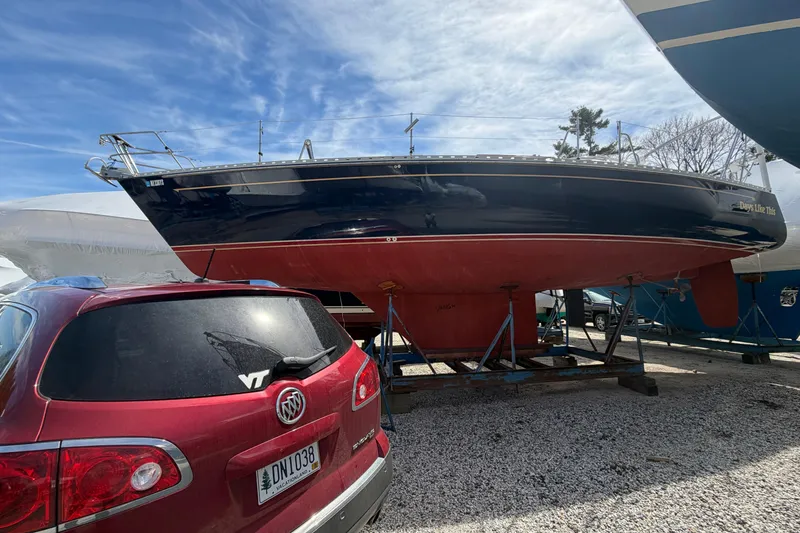 Slide: The Image of 1989 Freedom 38 Sloop sailboat on stands beside a red SUV in a boatyard. - 39