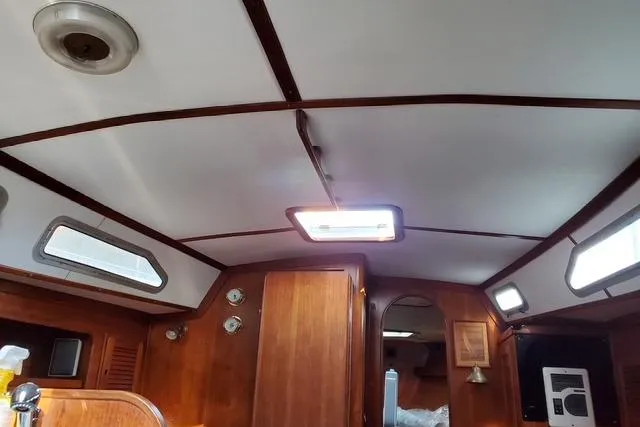 Slide: The Image of Interior of 1989 Freedom 38 Sloop sailboat with wooden paneling and ceiling lights. - 4