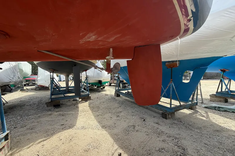 Slide: The Image of 1989 Freedom 38 Sloop sailboat on stands, hull and rudder visible. - 41