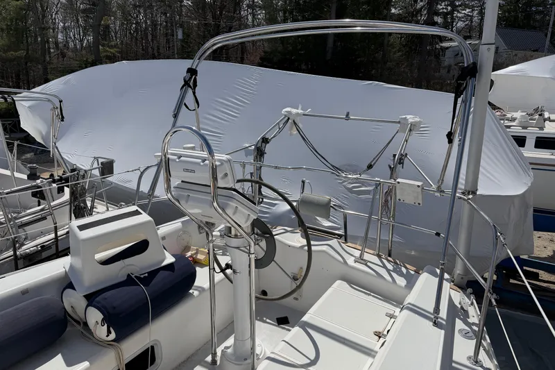 Slide: The Image of 1989 Freedom 38 Sloop sailboat cockpit with covered deck, featuring steering wheel and seating. - 45