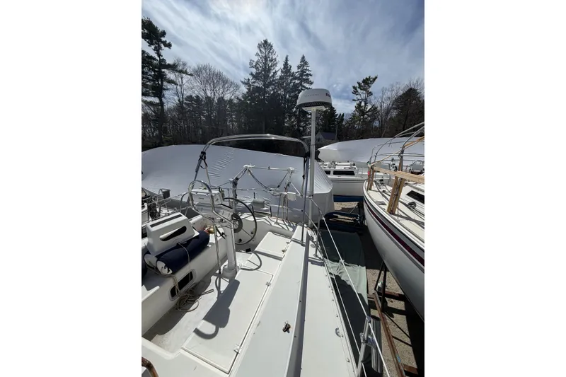 Slide: The Image of 1989 Freedom 38 Sloop sailboat docked, featuring a spacious deck and steering wheel. - 46