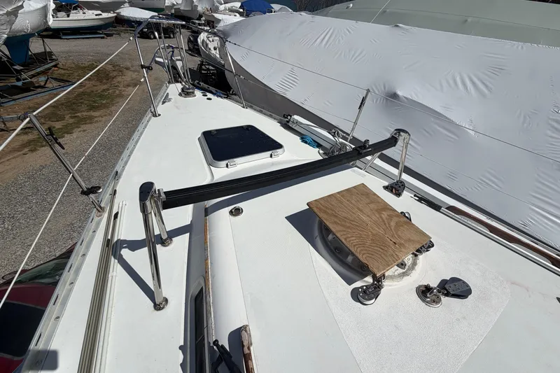 Slide: The Image of 1989 Freedom 38 Sloop deck view with rigging and covered sails in a boatyard. - 49