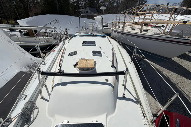 Slide: The Image of 1989 Freedom 38 Sloop sailboat on land, surrounded by other boats, under clear skies. - 51