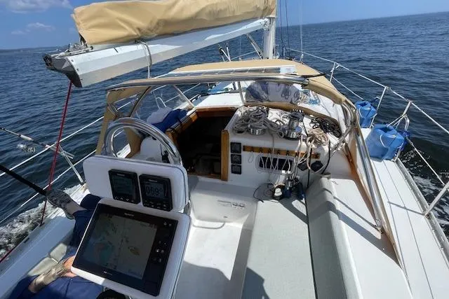 Slide: The Image of 1989 Freedom 38 Sloop sailing on open water, featuring navigation equipment and spacious deck. - 68
