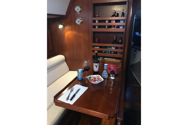 Slide: The Image of Cozy dining area in 1989 Freedom 38 Sloop with wine, salad, and beverages. - 7