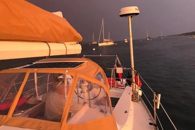Slide: The Image of 1989 Freedom 38 Sloop sailing at sunset with other boats in the background. - 70