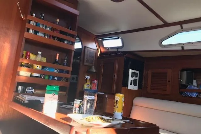 Slide: The Image of Interior of 1989 Freedom 38 Sloop yacht with dining area and wooden cabinetry. - 9