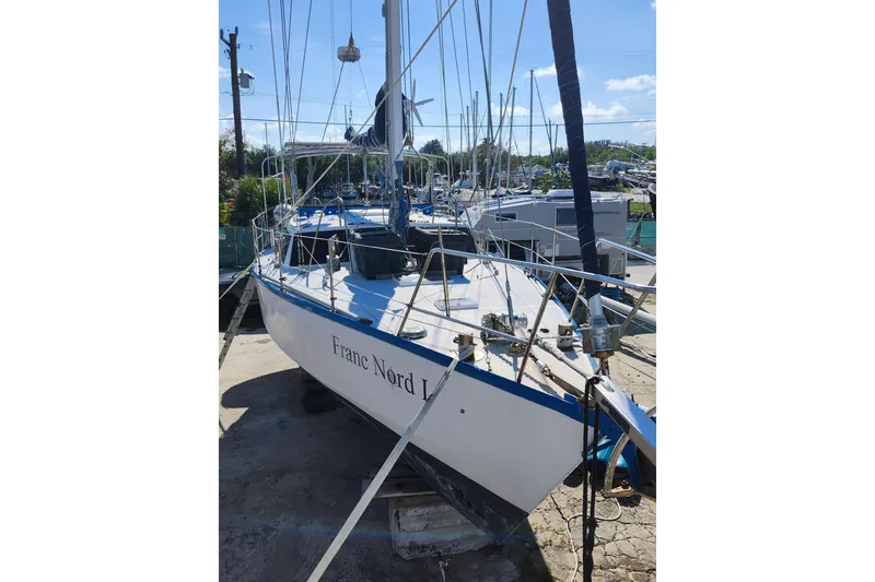 The Image of 1987 Custom Weld Exploration sailboat docked, featuring sleek design and blue accents. - 1