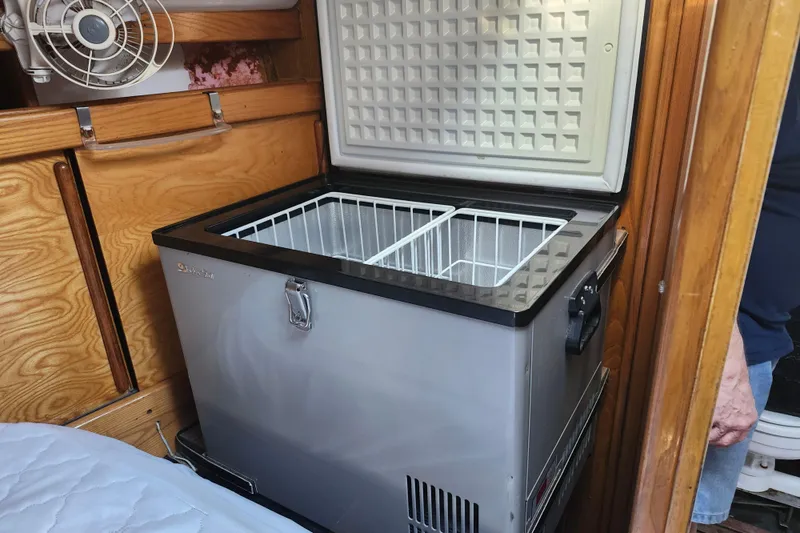 Slide: The Image of Open stainless steel freezer in a wooden cabin interior, Custom Weld Exploration 1987 model. - 17