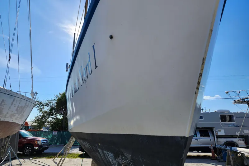Slide: The Image of 1987 Custom Weld Exploration boat on land, with vehicles and clear sky in background. - 28