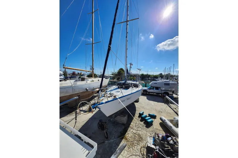 Slide: The Image of Sailboat "Custom Weld Exploration 1987" docked under clear blue sky. - 31