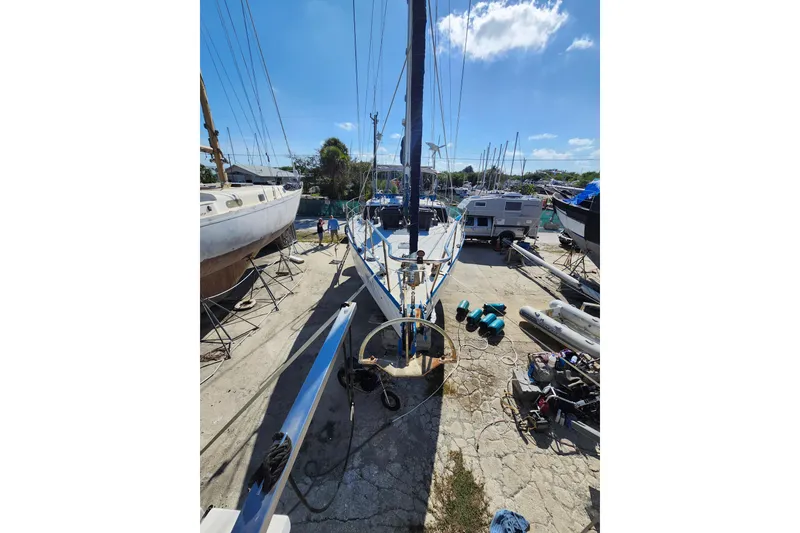 Slide: The Image of Sailboat in a boatyard, Custom Weld Exploration, 1987 model, surrounded by equipment. - 34
